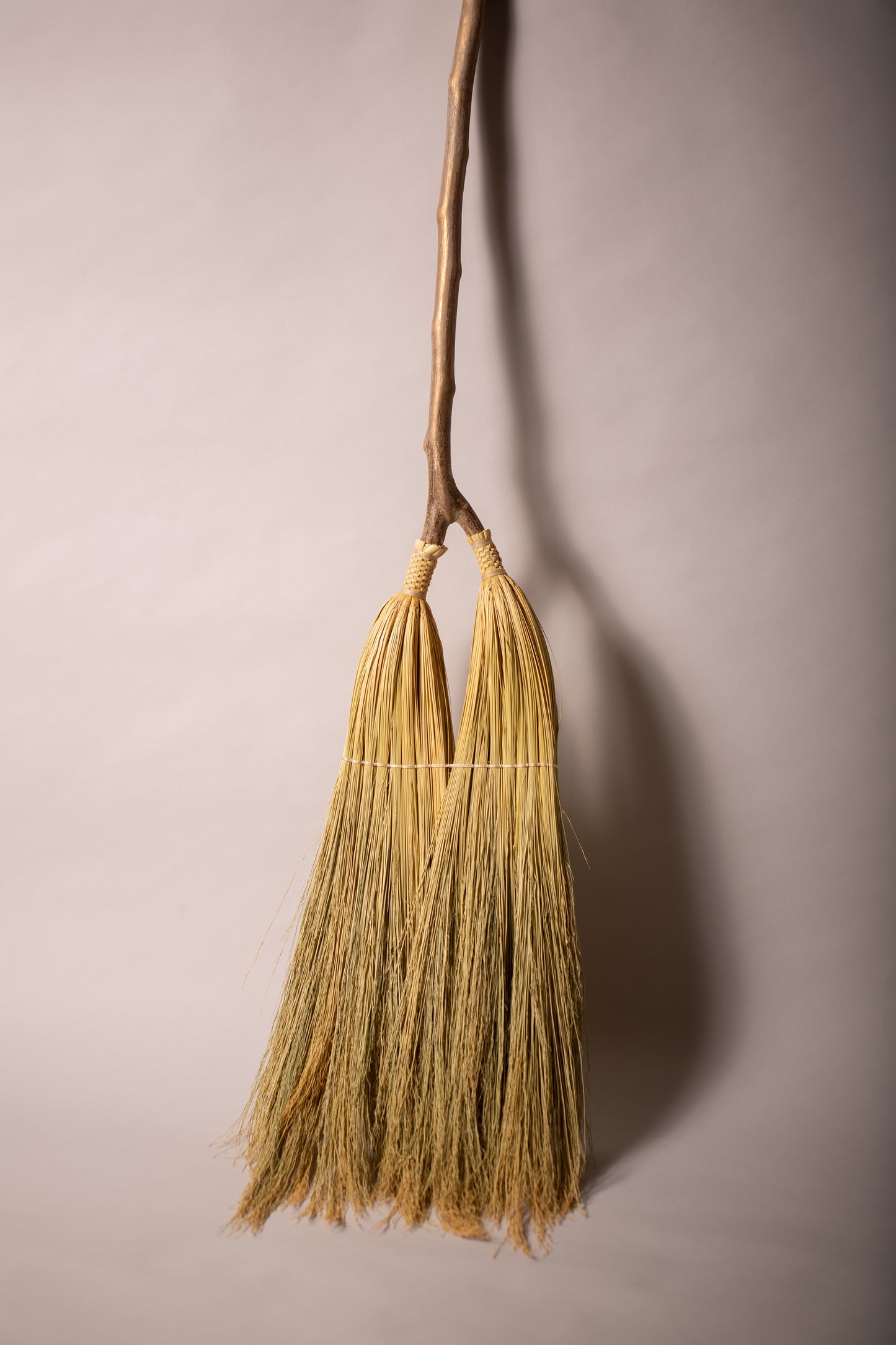 Double headed broom on hazel forked handle ivory twine natural broomcorn front view