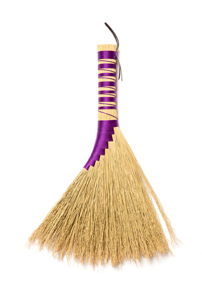 Broom with a purple handle on a white background