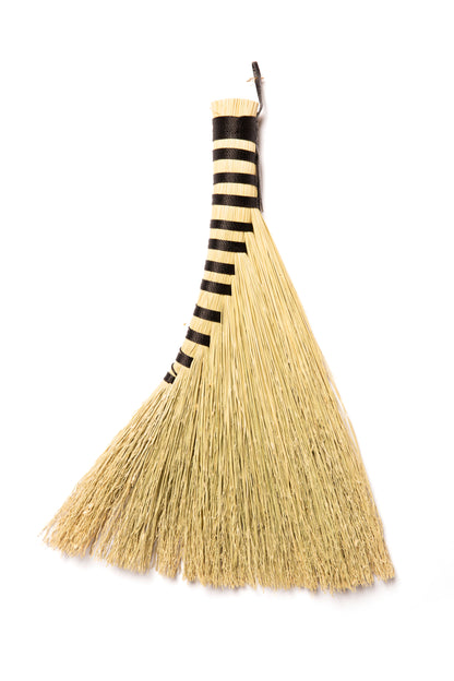 Broom with black twine and natural broomcorn on a white background